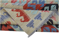 A handwoven Afghan Maimana kilim rug featuring geometric patterns in red, blue, and cream wool.