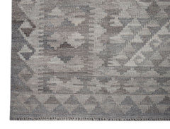 A handwoven Afghan Maiamana kilim rug featuring a grey geometric pattern in undyed natural wool.