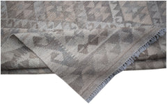 A handwoven Afghan Maimana kilim featuring a neutral geometric pattern in undyed natural wool.