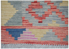 Handwoven Afghan Maimana kilim rug featuring a geometric pattern in red, blue, yellow, and grey.