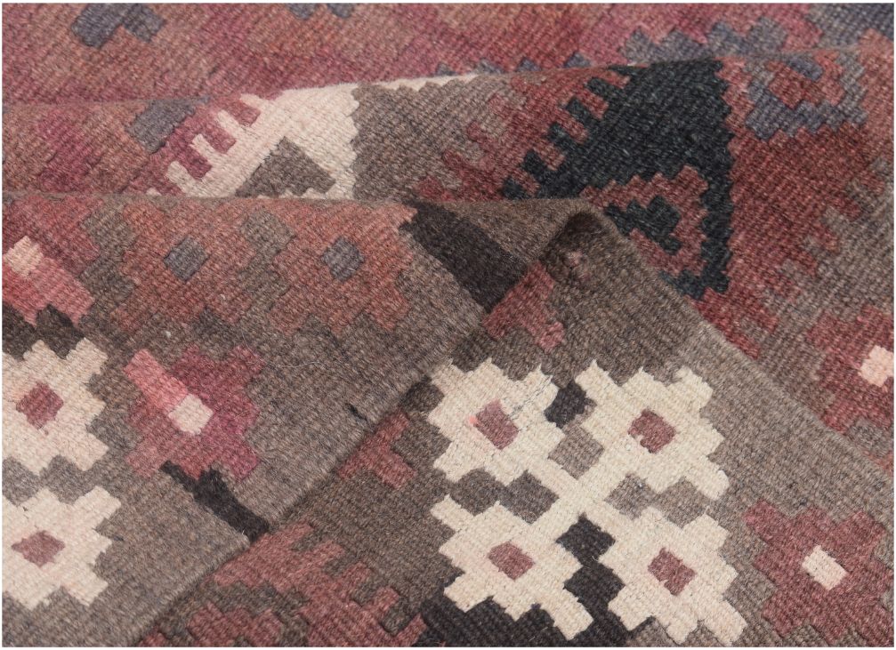 A handmade Afghan Maimana kilim rug featuring geometric patterns in shades of brown, red, and cream.