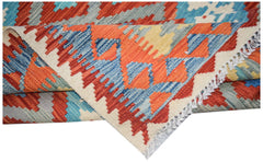 A handmade Afghan Maimana kilim rug featuring a geometric pattern in orange, blue, and cream.