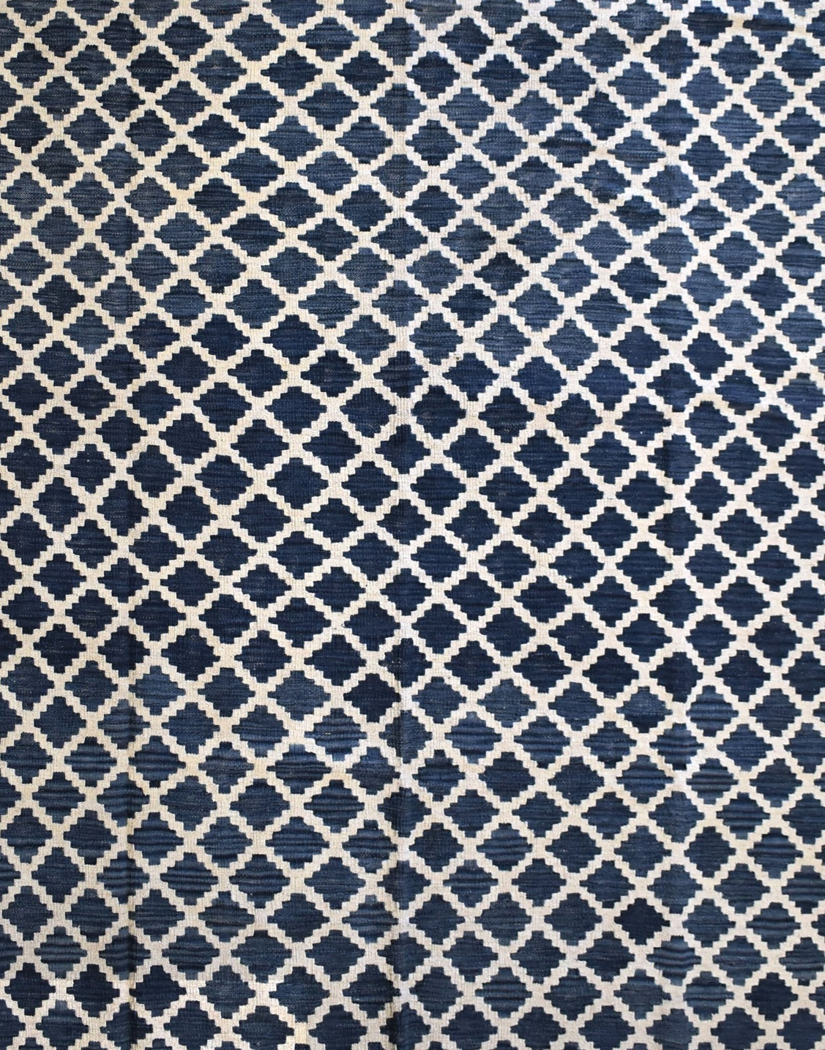 Handmade Afghan Maimana kilim rug featuring a repeating dark blue and cream geometric pattern.