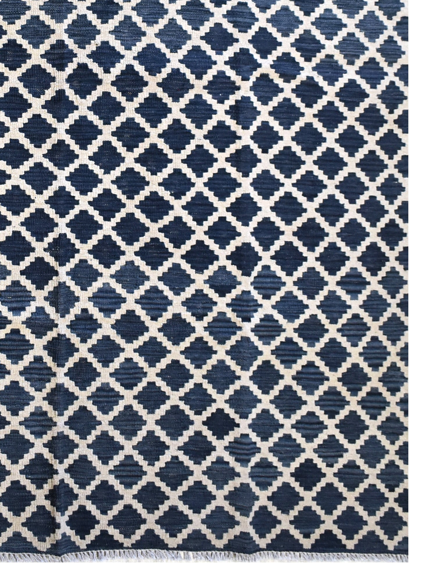 Handmade Afghan Maimana kilim rug featuring a dark blue and cream geometric lattice pattern.