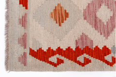 Handwoven Afghan Maimana kilim rug featuring geometric patterns in orange, pink, and cream tones.
