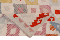 A handmade Afghan Maimana kilim rug featuring a geometric pattern in colorful wool.