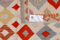 Handwoven Afghan Maimana kilim featuring a geometric diamond pattern in red, blue, and yellow.