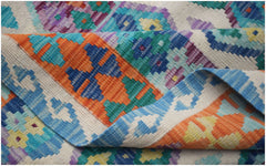 A handwoven Afghan Maimana kilim featuring a vibrant geometric pattern in wool.