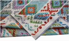 A handwoven Afghan Maimana kilim rug featuring a colorful geometric pattern on a cream background.