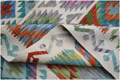 A handwoven Afghan Maimana kilim rug featuring a colorful geometric pattern on a wool base.