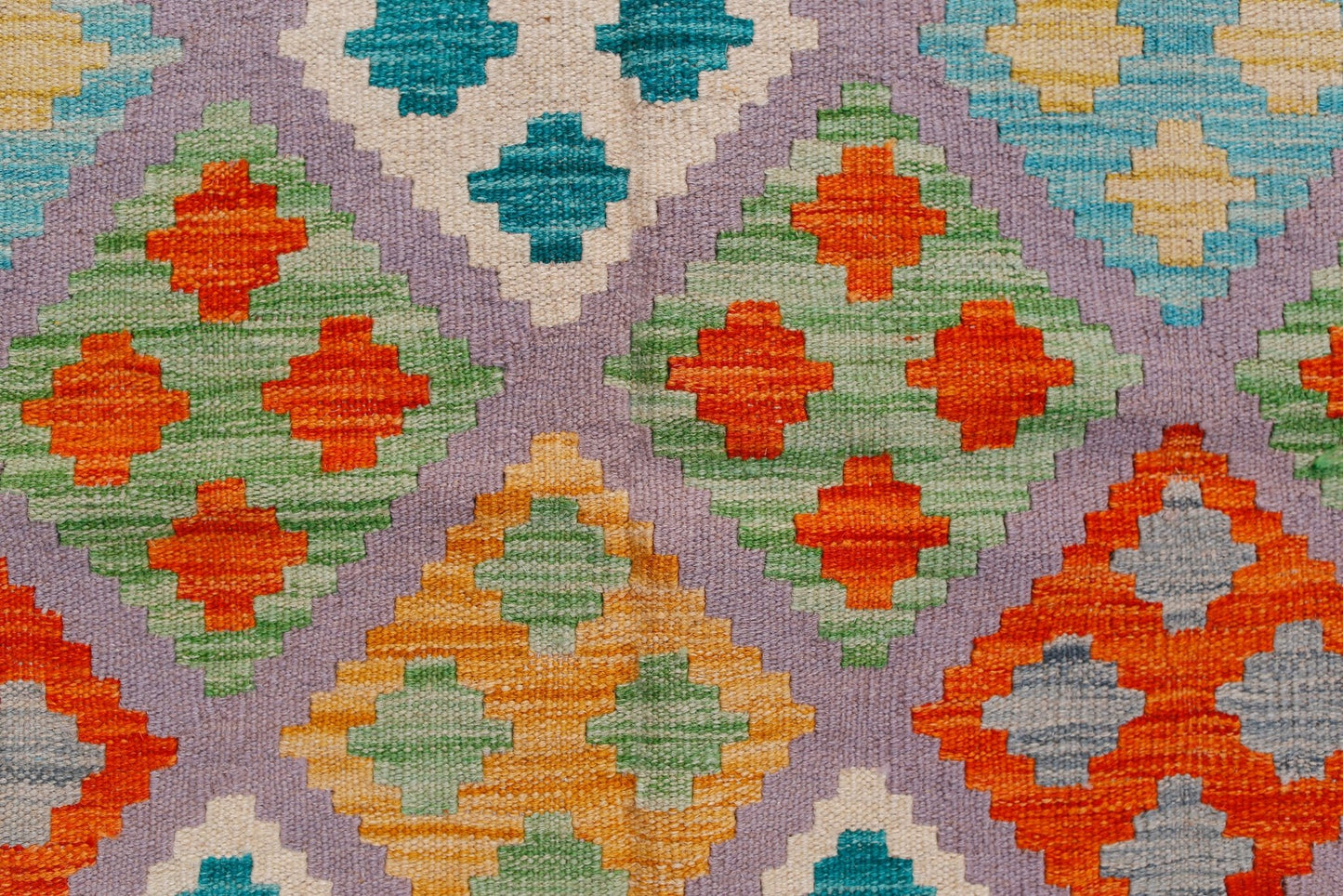 Handwoven Afghan Maimana kilim rug featuring a geometric diamond pattern in vibrant colors.