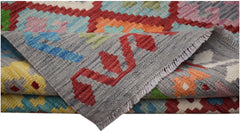 A handwoven Afghan Maimana kilim featuring a colorful geometric pattern and flatweave texture.
