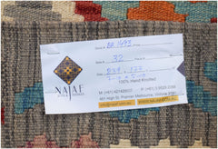 A handwoven Afghan Maimana kilim featuring a geometric pattern in vibrant, multi-colored wool.