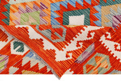 A handwoven Afghan Maimana kilim featuring a vibrant geometric pattern in wool.