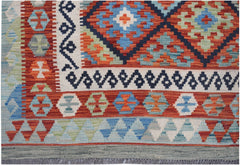 Handwoven Afghan Maimana kilim rug featuring a geometric pattern in vibrant red, blue, and green.