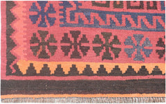 A handmade Afghan Maimana kilim rug featuring geometric patterns in red, blue, and orange wool.
