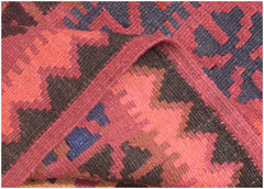 A handmade Afghan Maimana kilim rug featuring geometric patterns in red, brown, and blue wool.