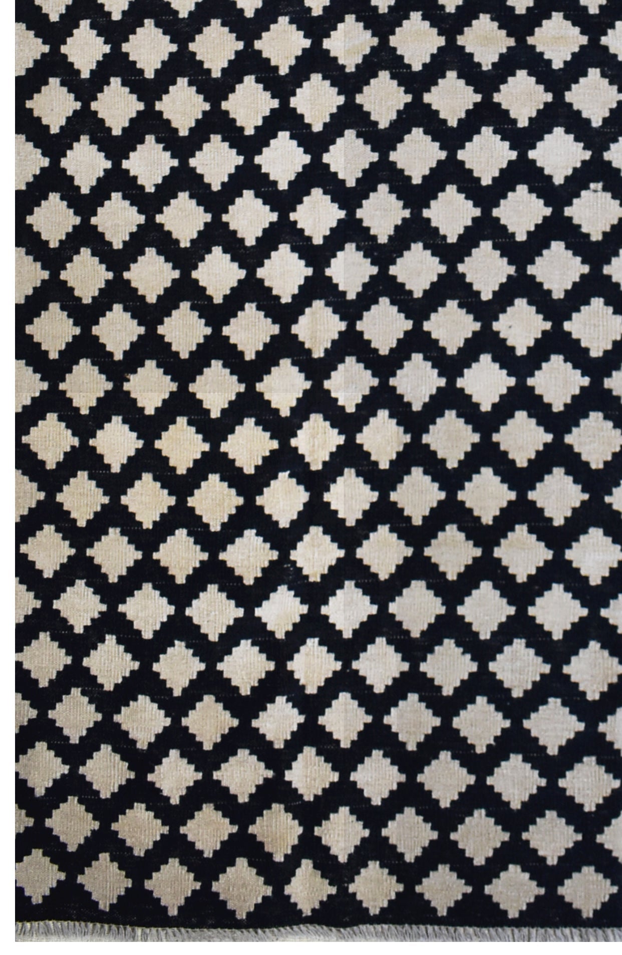 Handmade Afghan Maimana kilim rug featuring a repeating black and cream geometric pattern.