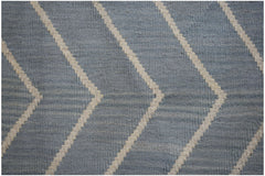 A handwoven wool Afghan Maimana kilim featuring a blue and cream geometric chevron pattern.
