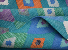 A handmade Afghan Maimana kilim rug featuring a vibrant geometric pattern in wool.