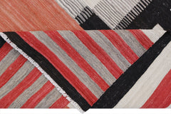 A handmade Afghan Maimana kilim rug featuring a geometric pattern of red, black, and grey stripes.