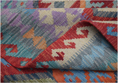 A handmade Afghan Maimana kilim rug featuring a vibrant geometric pattern in wool.