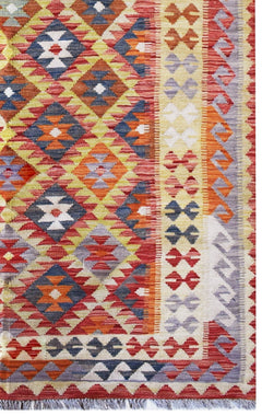 Handmade Afghan Maimana kilim rug featuring a vibrant geometric diamond pattern in wool.