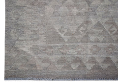 A handwoven Afghan Maimana kilim rug featuring a neutral geometric pattern in undyed wool.