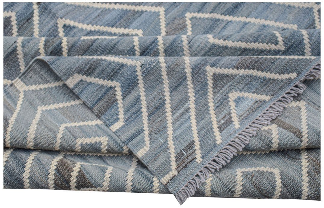 A blue and grey handwoven Afghan Maimana kilim rug featuring a geometric chevron pattern.