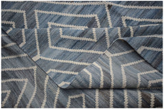 A handwoven Afghan Maimana kilim rug featuring a blue and white geometric pattern.