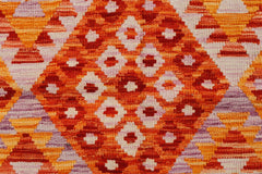 Handwoven Afghan Maimana kilim featuring a vibrant geometric diamond pattern in orange and red.