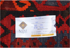 A handwoven Afghan Maimana kilim featuring a geometric pattern in shades of red and dark blue.