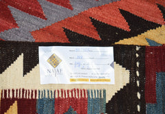A handmade Afghan Maimana kilim featuring a geometric pattern in red, blue, and yellow tones.