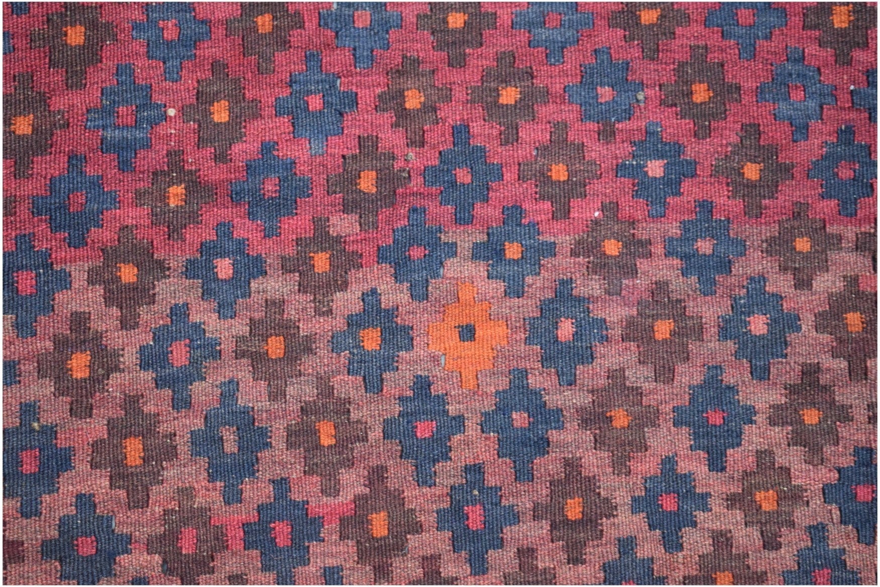 Handmade Afghan Maimana kilim rug featuring a repeating geometric pattern in red, blue, and orange.