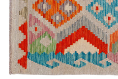 A handmade Afghan Maimana kilim featuring a vibrant geometric pattern in wool.