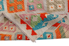 A handmade Afghan Maimana kilim rug featuring a colorful geometric pattern on a flatweave surface.