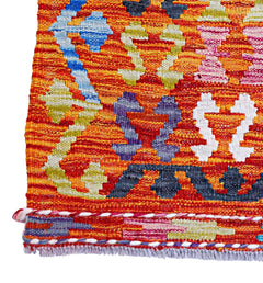 Handwoven Afghan Maimana kilim featuring a vibrant orange background with geometric patterns.