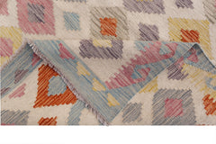 A handmade Afghan Maimana kilim rug featuring a geometric pattern in colorful wool.