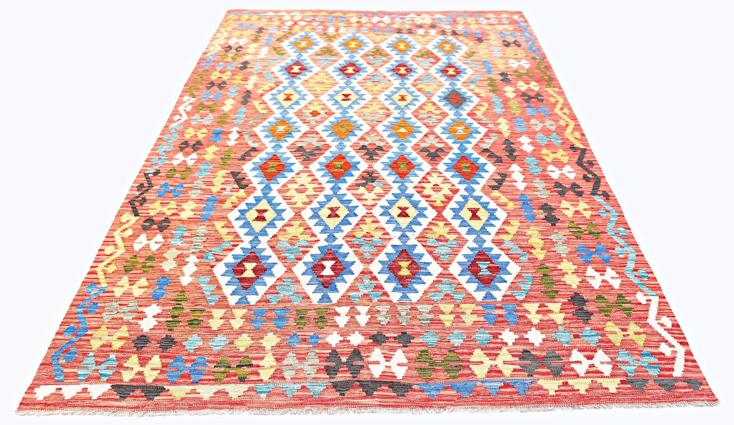 An Afghan Maimana Kilim rug featuring a vibrant geometric diamond pattern on a red background.