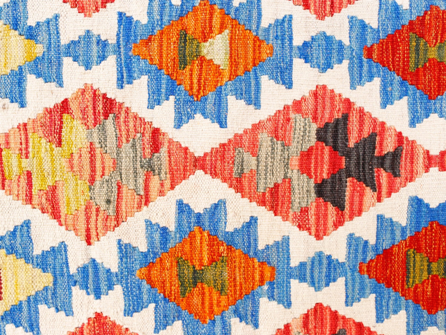 Handwoven Afghan Maimana kilim featuring a geometric diamond pattern in vibrant wool colors.