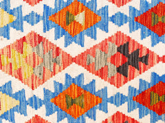Handwoven Afghan Maimana kilim featuring a geometric diamond pattern in vibrant wool colors.