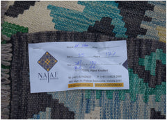 A handmade Afghan Maimana kilim featuring a geometric pattern in blue, green, and cream tones.