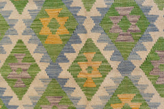 Handwoven Afghan Maimana kilim featuring a geometric diamond pattern in green, yellow, and purple.