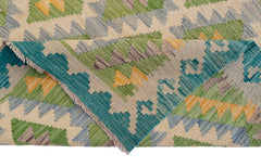 A handwoven Afghan Maimana kilim rug featuring a geometric pattern in green, blue, and yellow.