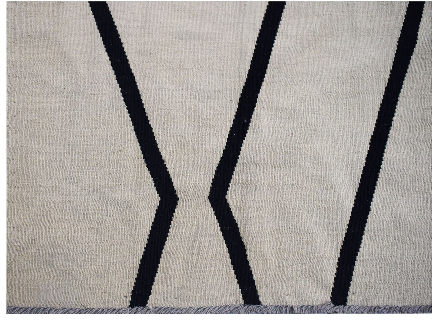 Handwoven Afghan Maimana kilim featuring a minimalist black geometric pattern on a cream background.