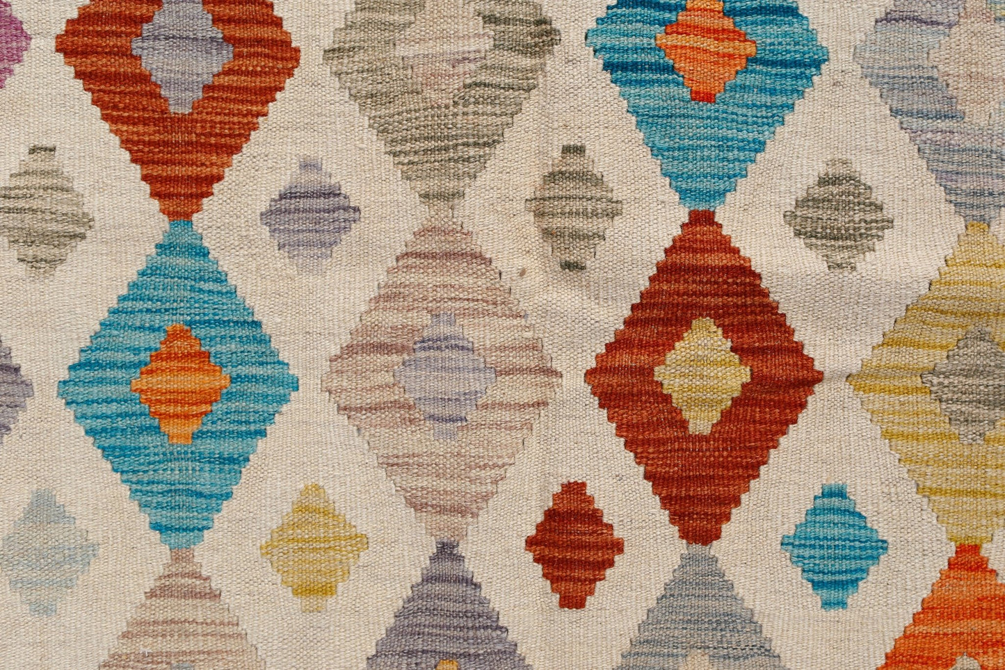 Handwoven Afghan Maimana kilim featuring a colorful geometric diamond pattern on a cream background.