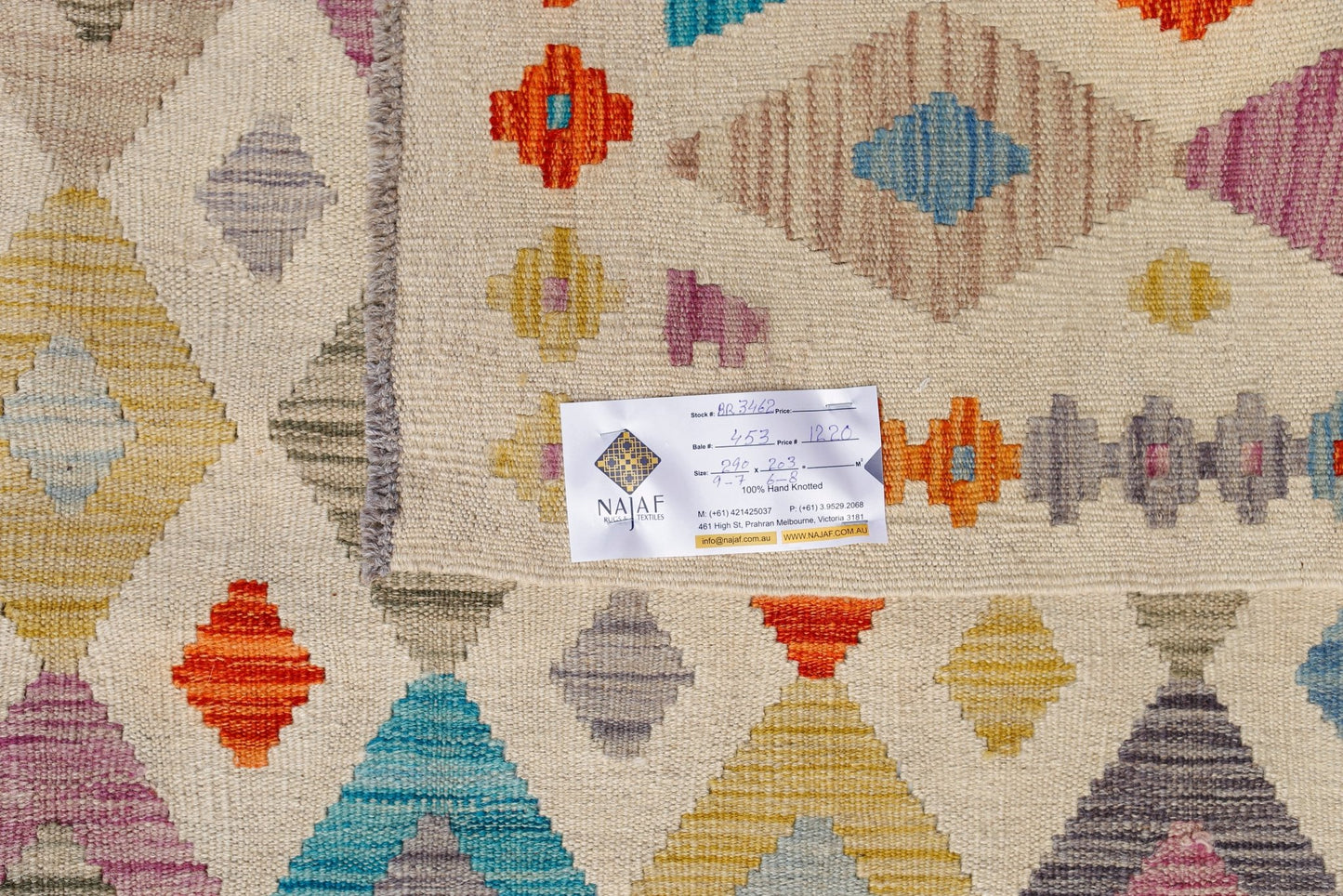 Handwoven Afghan Maimana Kilim rug featuring a geometric pattern in vibrant multicolored diamonds.