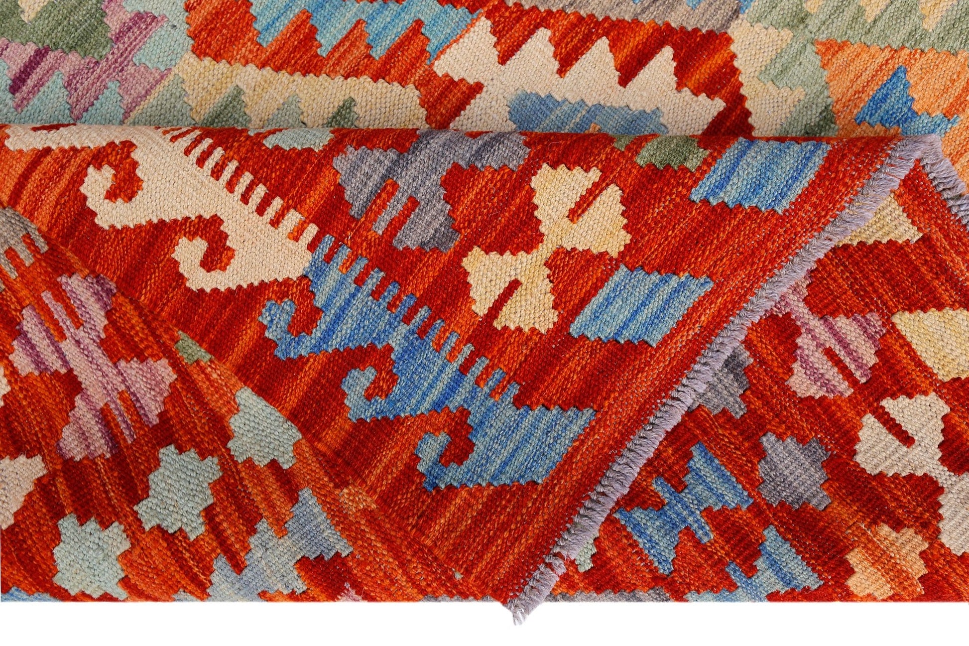 A handwoven Afghan Maimana kilim featuring a vibrant geometric pattern in red, blue, and cream.