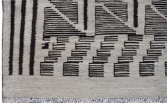 Handmade Afghan Maimana kilim rug featuring a geometric pattern in black and natural wool tones.