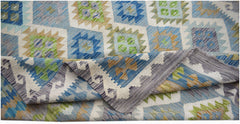 A handmade Afghan Maimana kilim rug featuring a geometric pattern in blue, green, and tan wool.